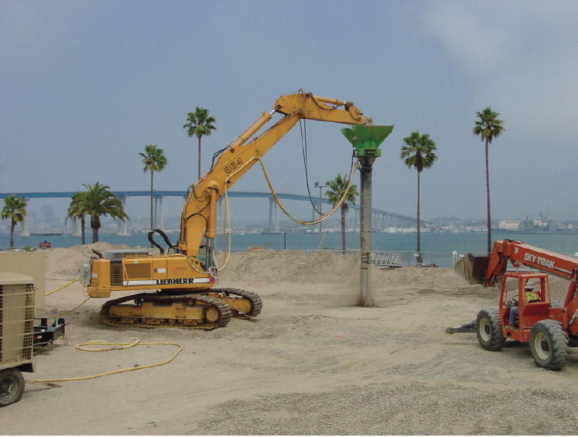 Vibro Stitcher® on a Liebherr 964 in the foreground and Cesar Chavez bridge in the background.